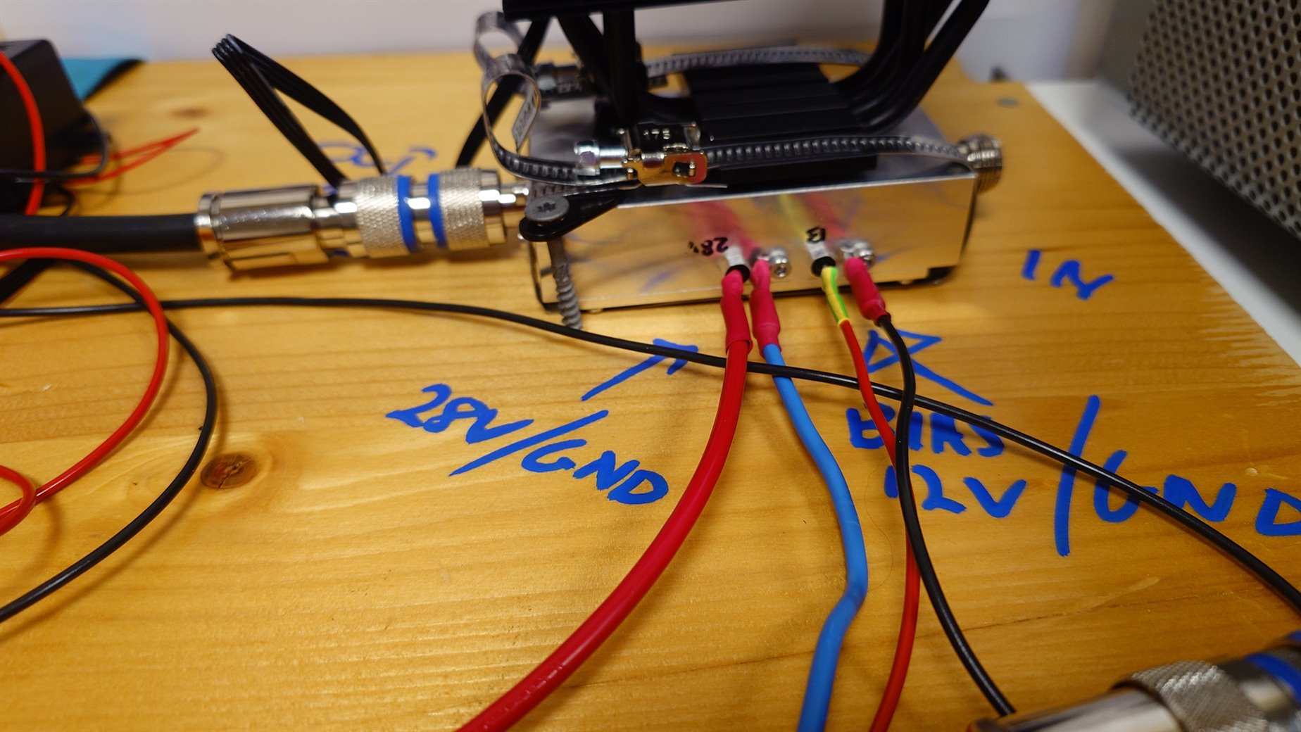 Close-up of the amplifier feedthrough terminals and the hand-written board labelling
